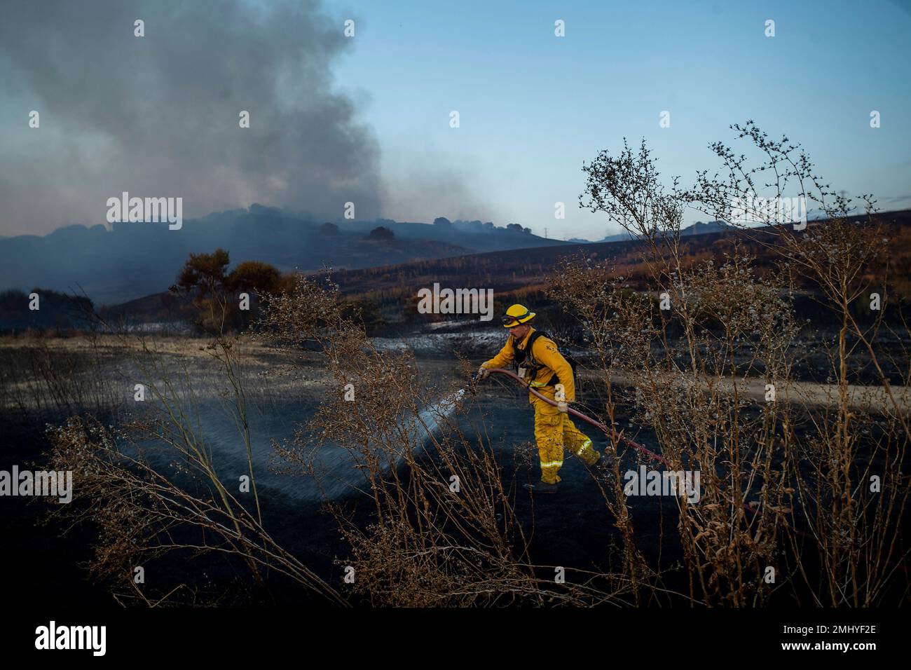 Firefighter William Schimpf sprays water while battling the American Fire in American Canyon