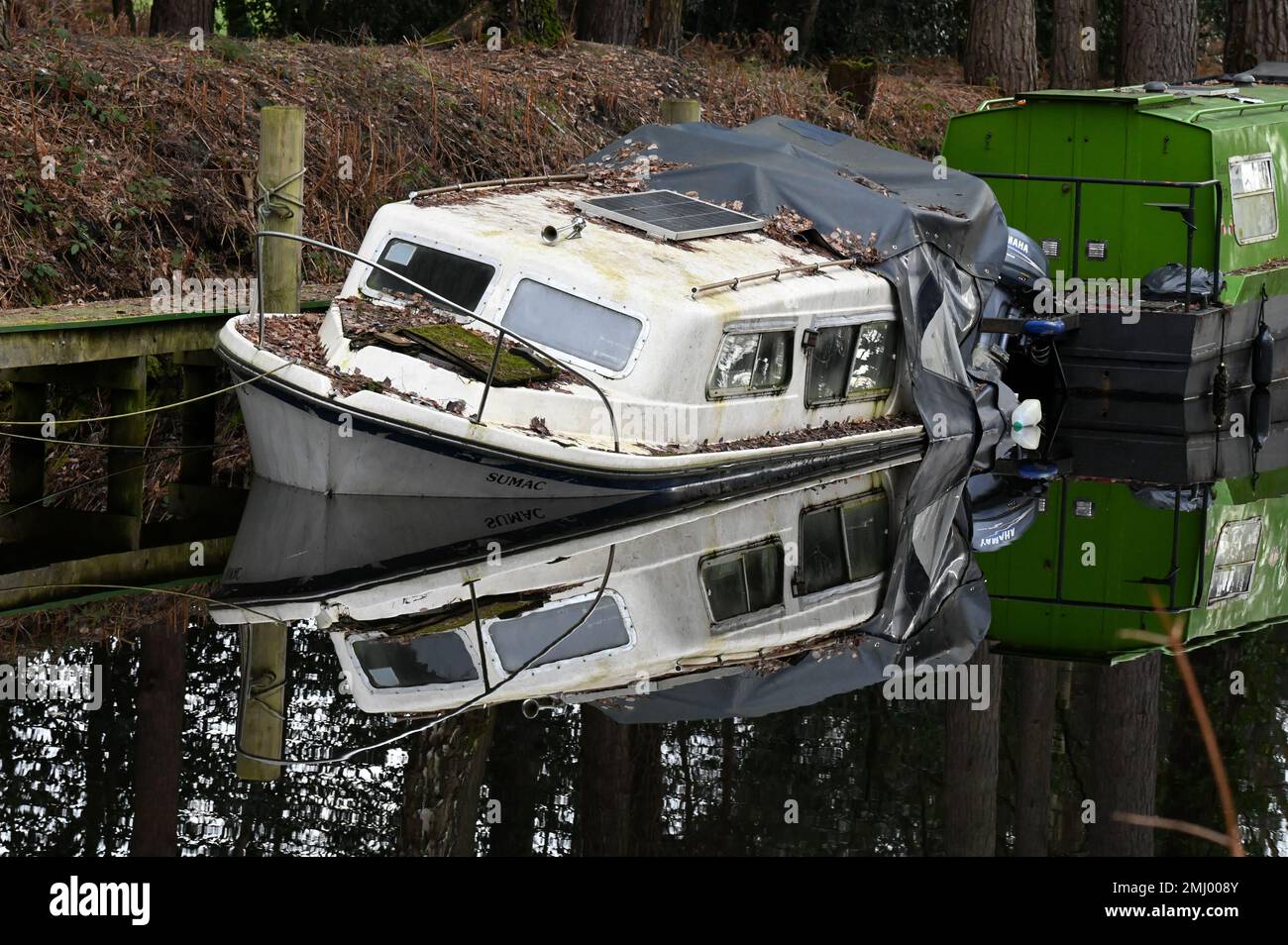 A boat listing at an angle along the beautiful Basingstoke Canal in
