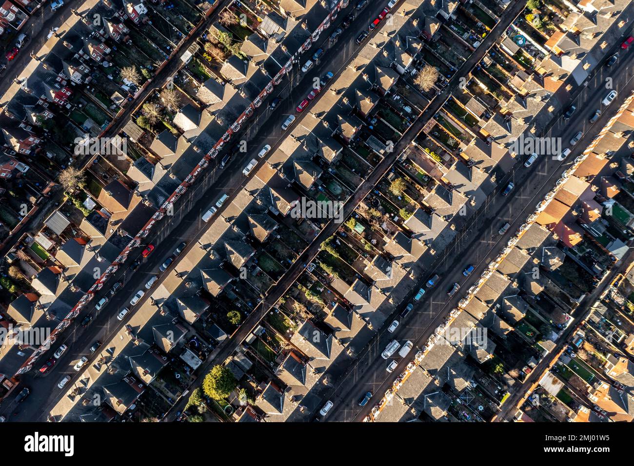 An aerial view directly above of the rooftops of rows of back to back terraced houses with alleyways and gardens in a working class area of a Northern Stock Photo