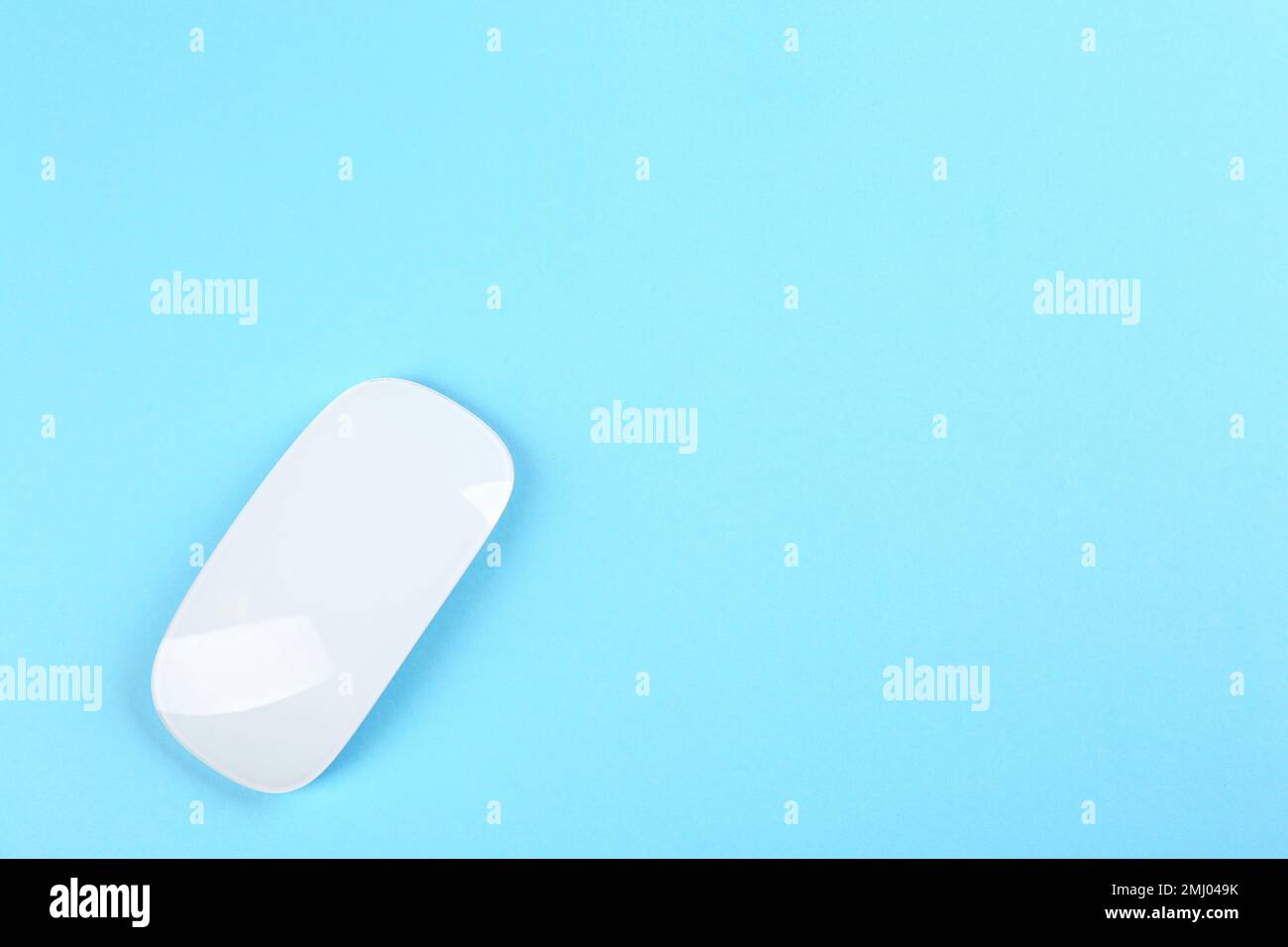 Modern wireless optical mouse on light blue background, top view. Space for text Stock Photo