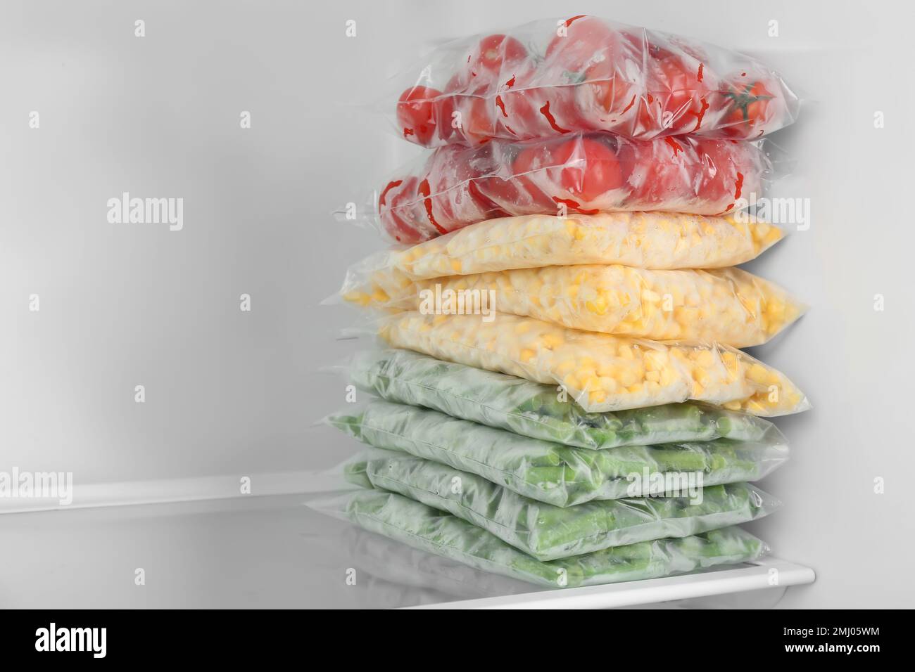 Plastic bags with different frozen vegetables in refrigerator Stock Photo Alamy