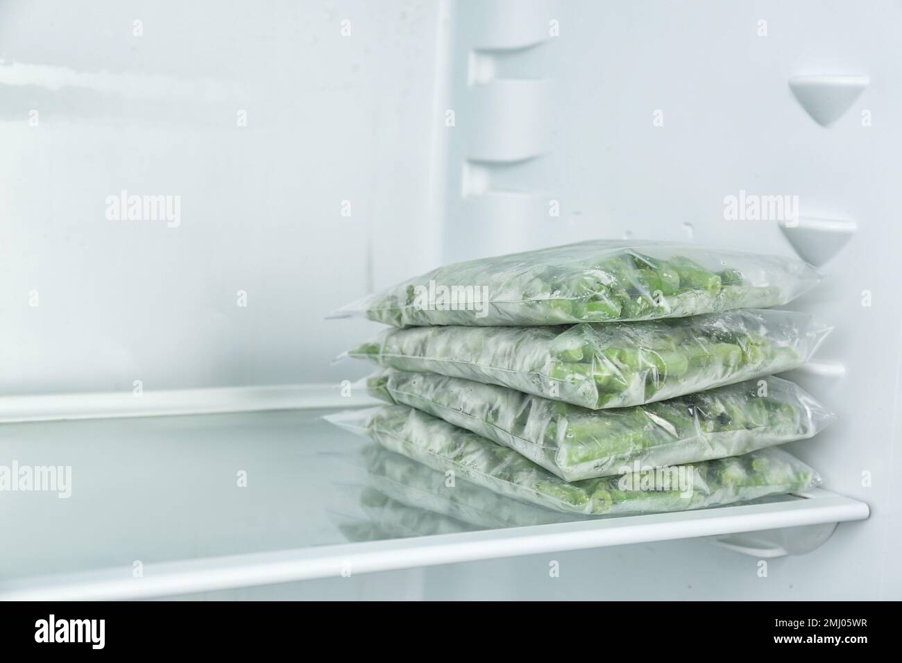 Plastic bags with different frozen vegetables in refrigerator Stock Photo Alamy