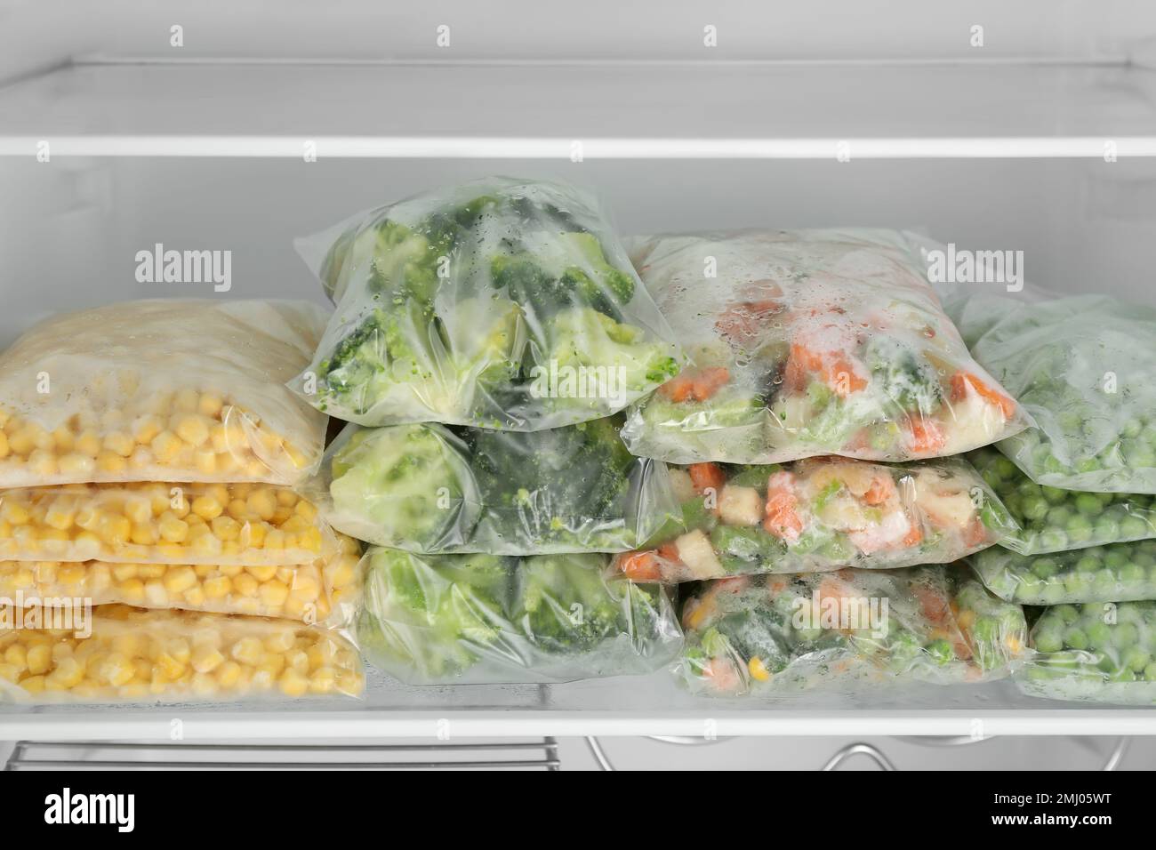 Plastic bags with different frozen vegetables in refrigerator Stock Photo Alamy