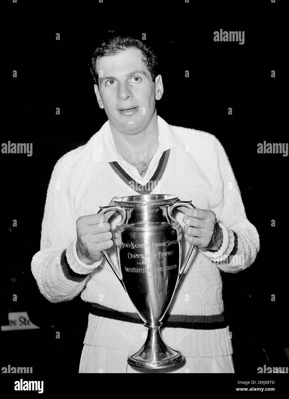 Tennis ace Dick Savitt poses with the championship trophy at the Seventh Regiment Armory in New