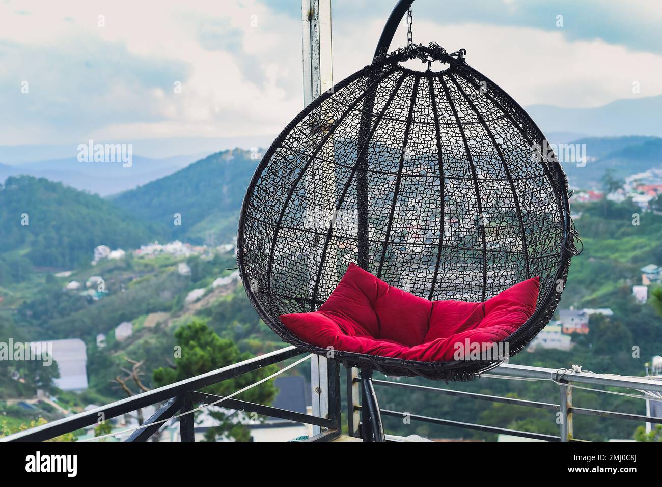 Hanging chair with pillow against mountains in Da Lat city in Vietnam Stock Photo