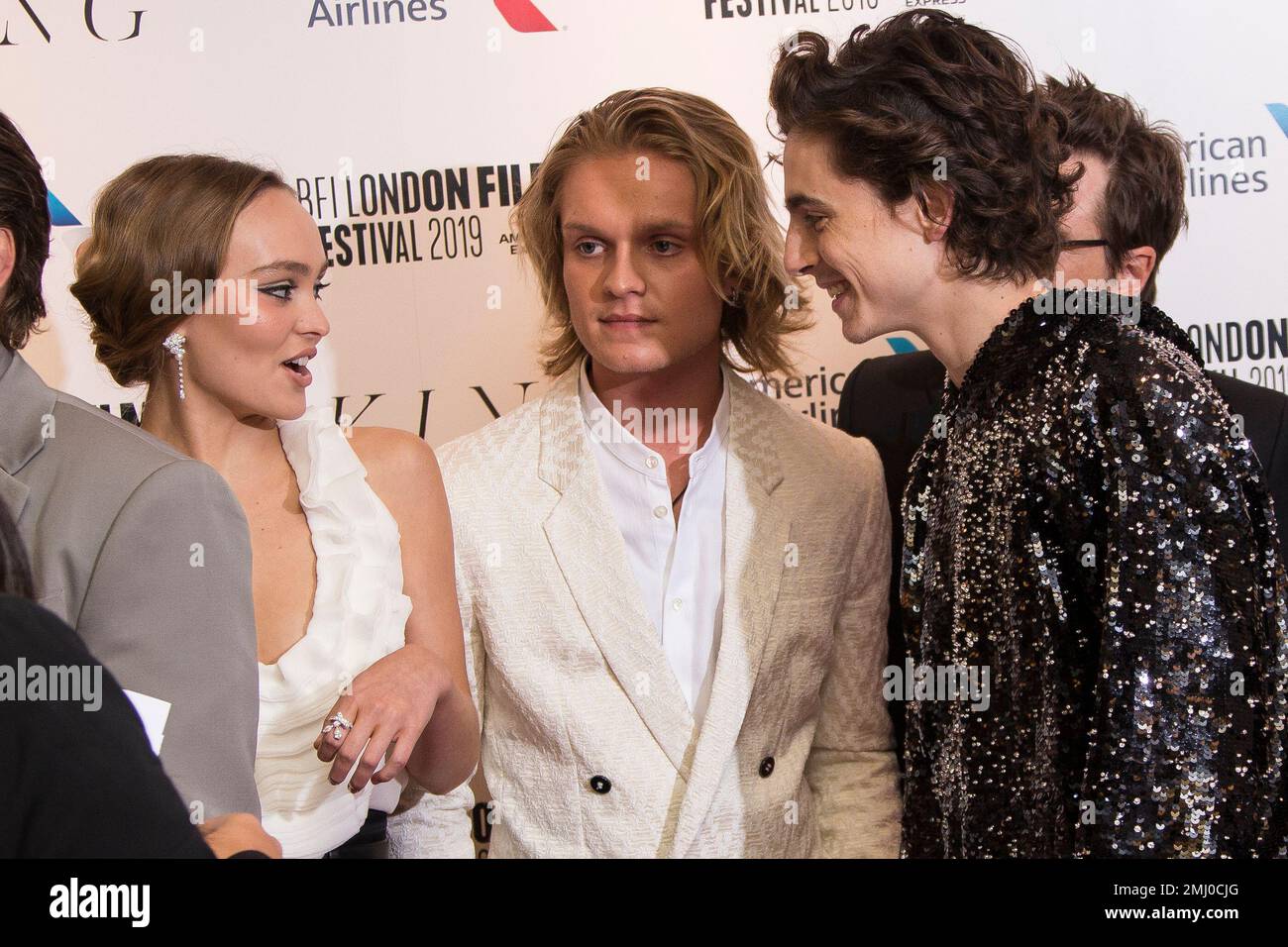 Actors Lily-Rose Depp, Tom Glynn-Carney centre, and Timothee Chalamet chat  with one another as they pose for photographers upon arrival at the  premiere of the 'The King' which is screened as part