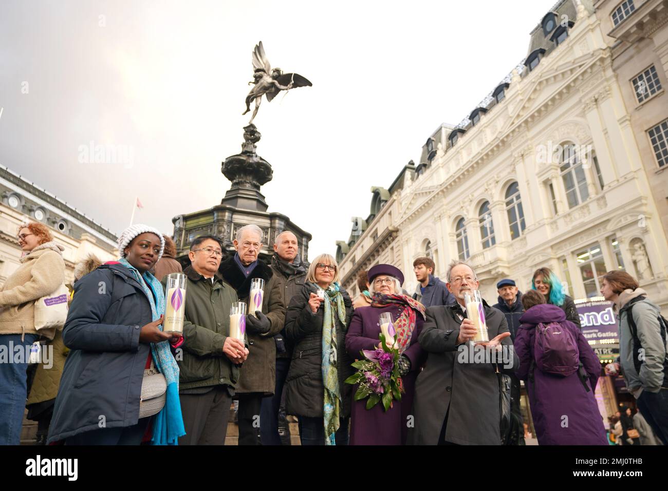 Robert Rinder MBE (fourth left) with survivors of the Holocaust holding lit memorial candles at Piccadilly Circus, central London, as a selection of entries from the Holocaust Memorial Trust's (Extra)Ordinary Portraits competition, as well as new photographs of genocide survivors taken by photographer Rankin, are shown on the video screens, to mark Holocaust Memorial Day. Picture date: Friday January 27, 2023. Stock Photo