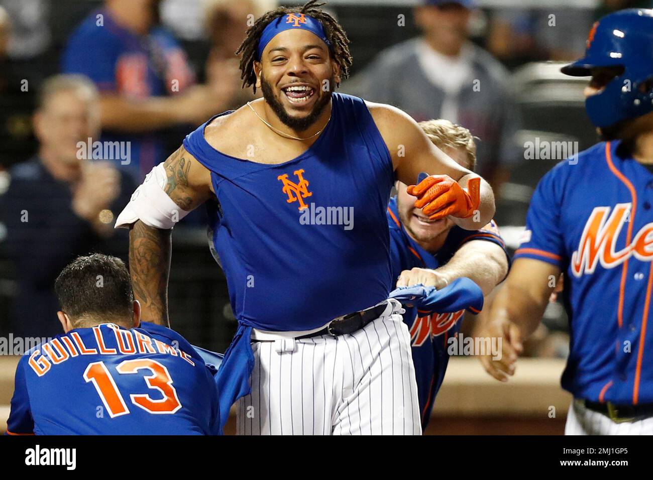 CORRECTS TO THREE-RUN HOME RUN NOT SOLO HOME RUN -New York Mets shortstop Luis  Guillorme (13) and Pete Alonso, right, tear the jersey off teammate Dominic  Smith after Smith's 11th inning walkoff