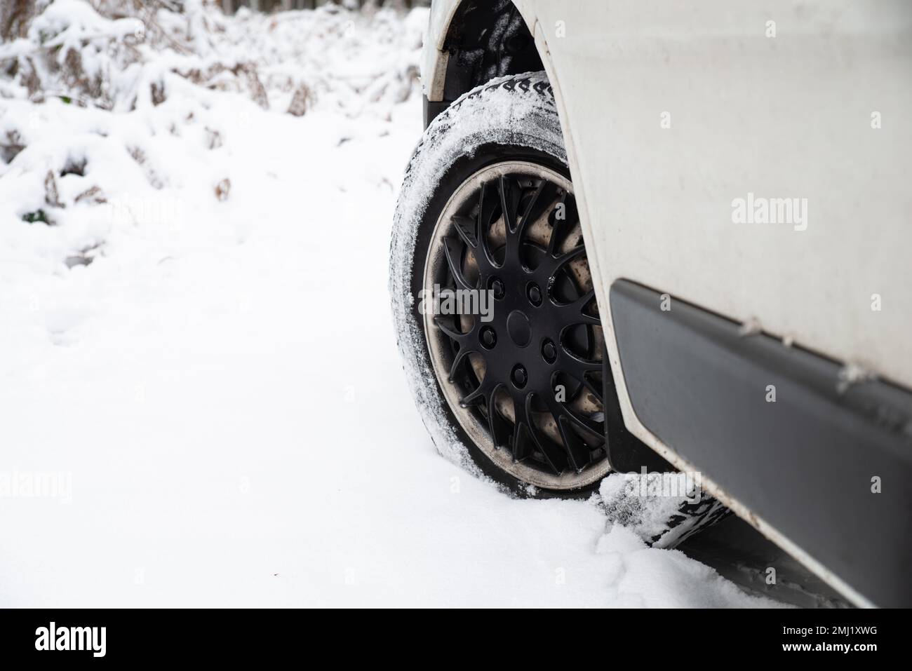 Car with winter tires on a snow covered road, winter weather, slippery