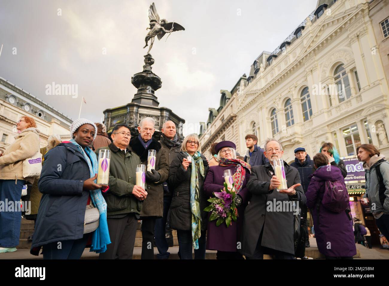 Robert Rinder (fourth left) with survivors of the Holocaust holding lit memorial candles at Piccadilly Circus, central London, as a selection of entries from the Holocaust Memorial Trust's (Extra)Ordinary Portraits competition, as well as new photographs of genocide survivors taken by photographer Rankin, are shown on the video screens, to mark Holocaust Memorial Day. Picture date: Friday January 27, 2023. Stock Photo