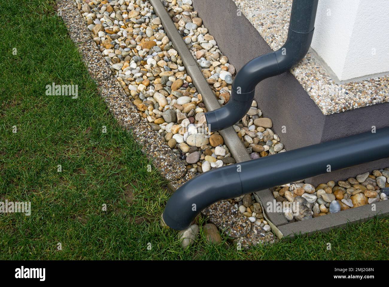 Gutter elbow leads rainwater into the garden. Drainage system. Stock Photo