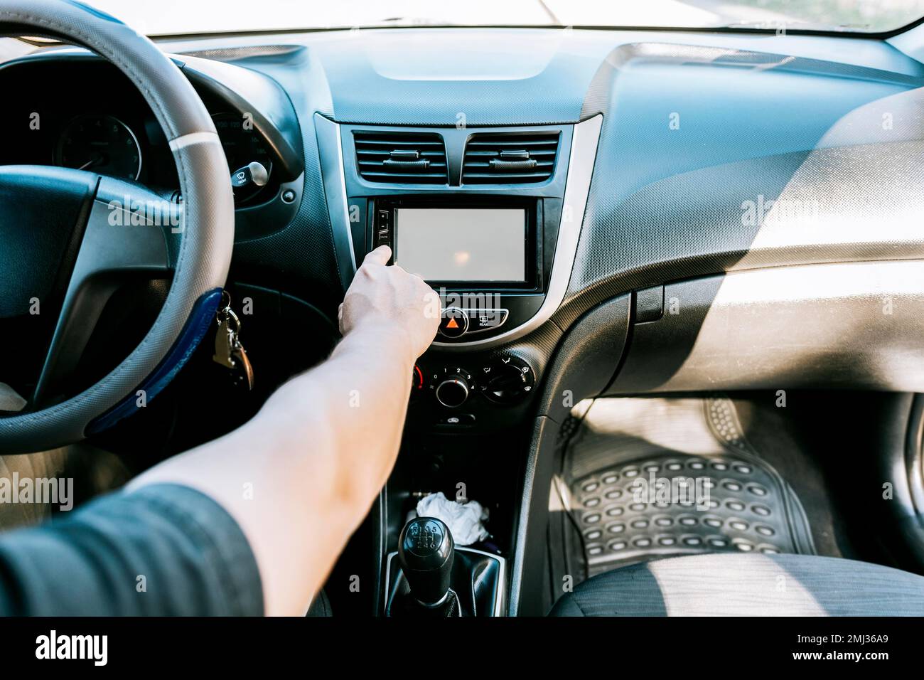 Close up of driver tuning into the radio station. Distracted driver
