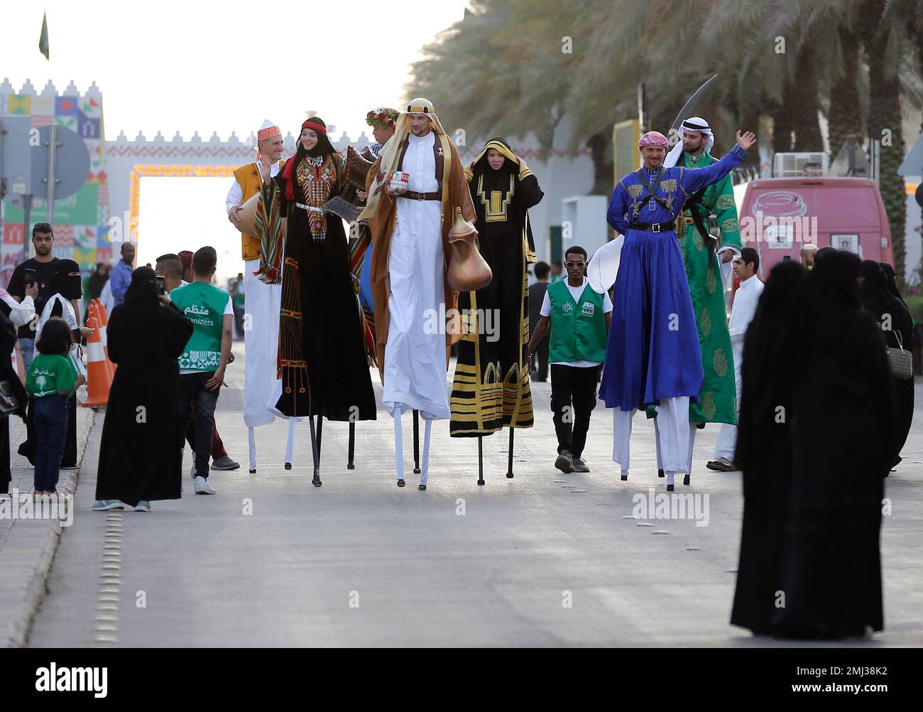 Dancers in traditional Saudi costumes perform on stilts marking