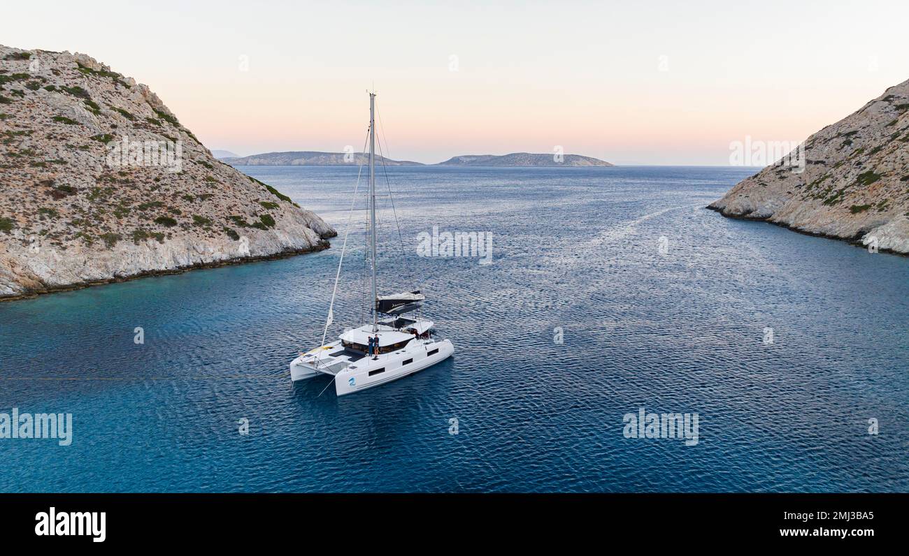 Sailing catamaran in a bay of Levitha Island, Greek Island, South Aegean Sea, Greece Stock Photo
