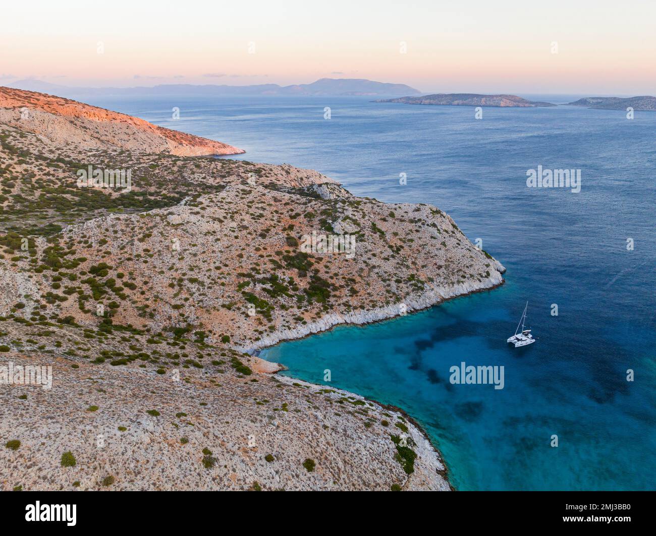 Sailing catamaran in a bay of Levitha Island, Greek Island, South Aegean Sea, Greece Stock Photo
