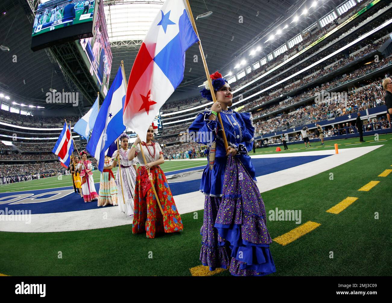 Dancers hold flags of nations of hispanic heritage honoring Hispanic  Heritage Month prior to a NFL football game between the Miami Dolphins and  Dallas Cowboys in Arlington, Texas, Sunday, Sept. 22, 2019. (