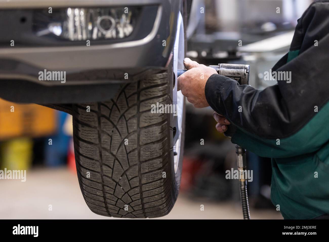 Car, auto mechanic changing tires, wheels on the car by pneumatic wrench, service center Stock Photo