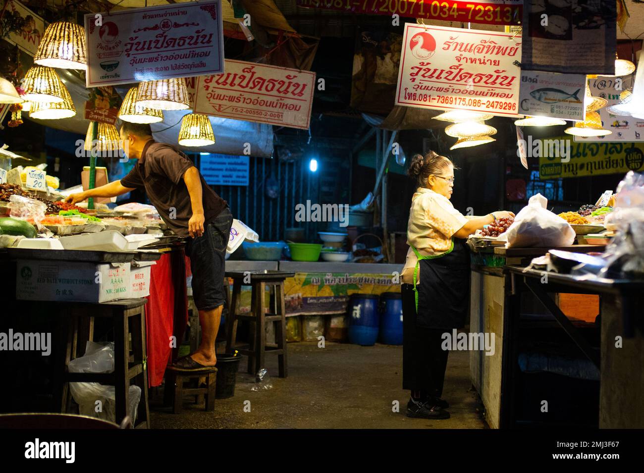 Vendors clean up after a long day after the crowds have all gone home in Thailand Stock Photo