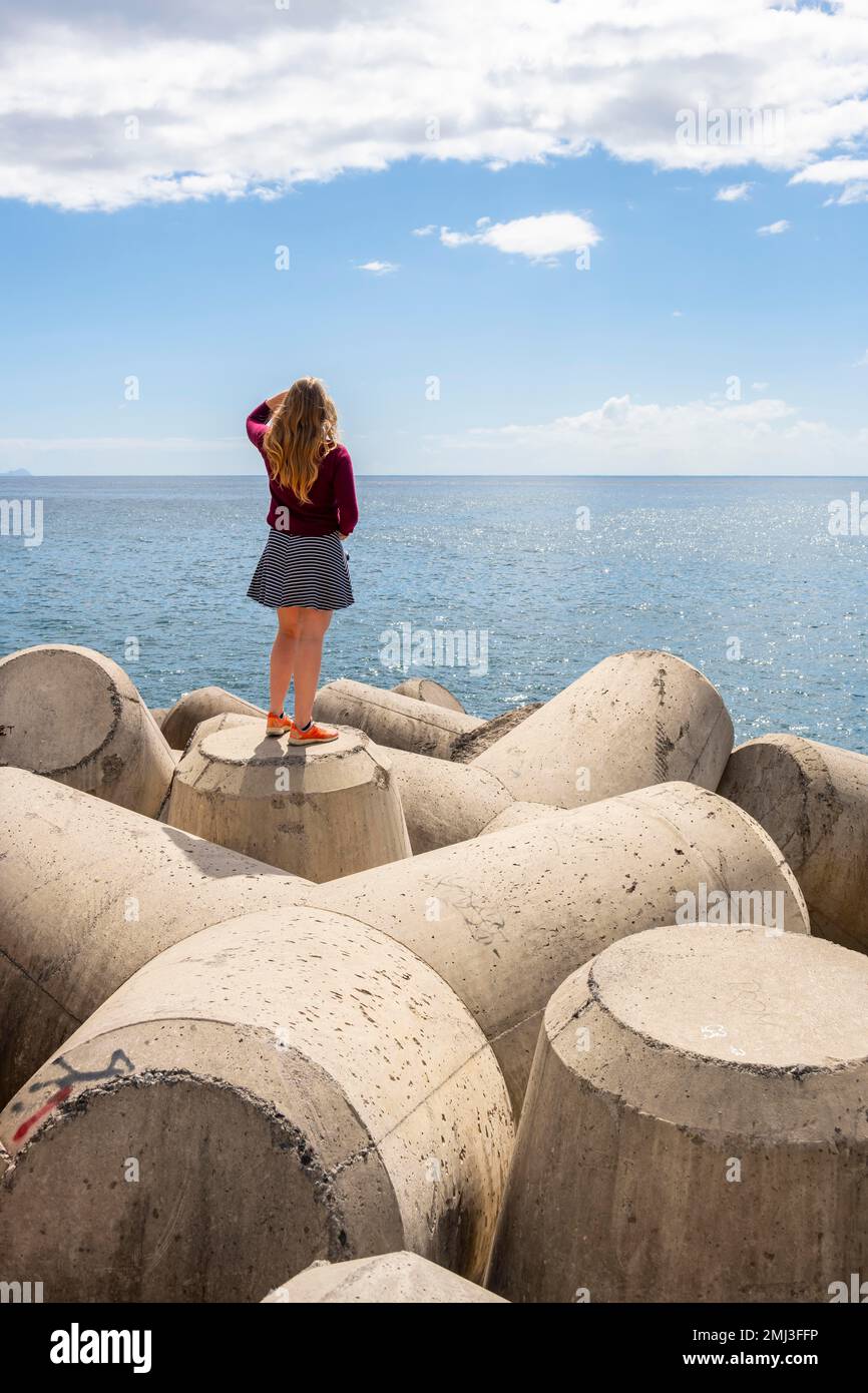 Young woman standing by the sea, Funchal, Madeira, Portugal Stock Photo
