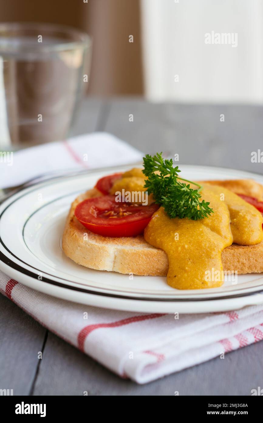 Vegan Welsh rarebit Toasted bread and tomatoes with a vegan cheese