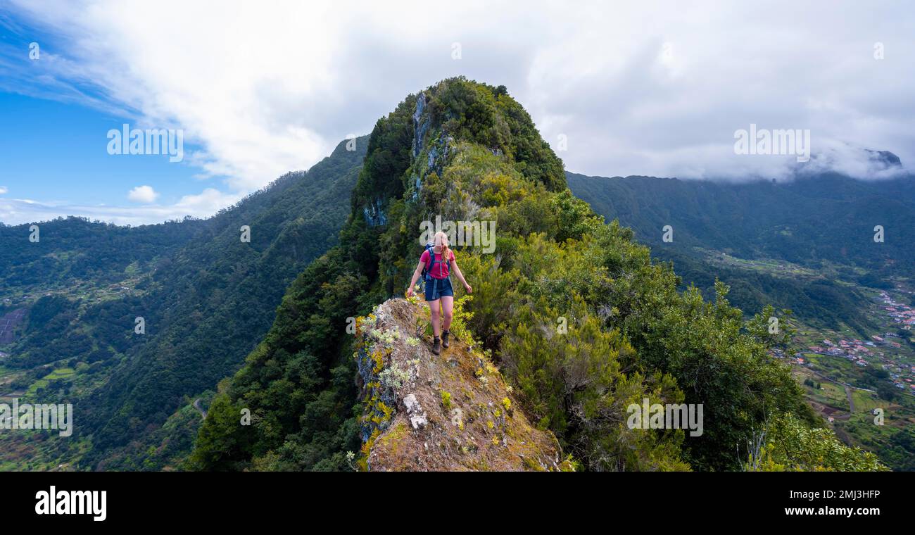 Hiker on the steep ridge of Pico do Alto, Madeira, Portugal Stock Photo