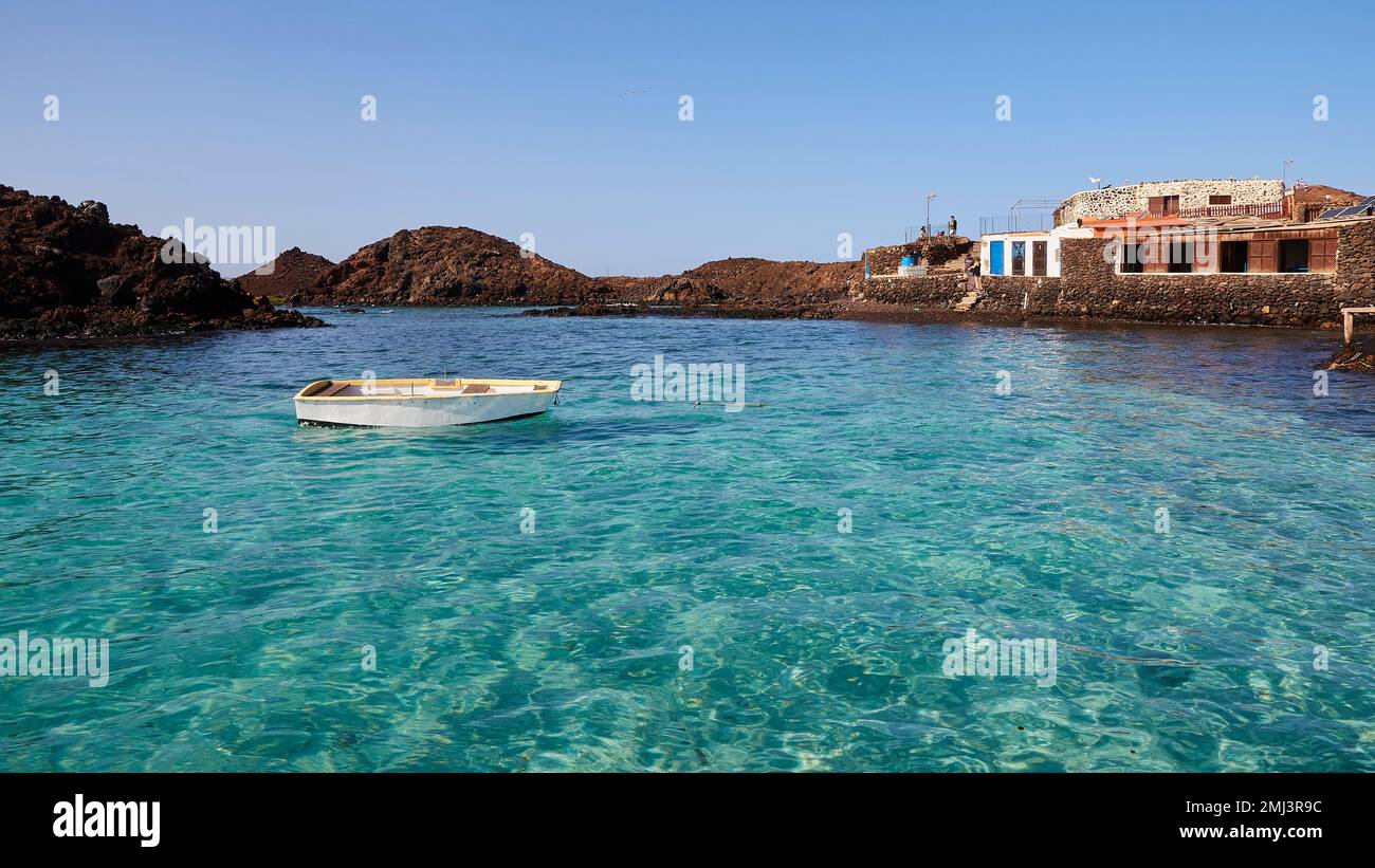 Harbour settlement, north, Los Lobos Island, nature reserve, turquoise sea, small boat, blue cloudless sky, Fuerteventura, Canary Islands, Spain Stock Photo
