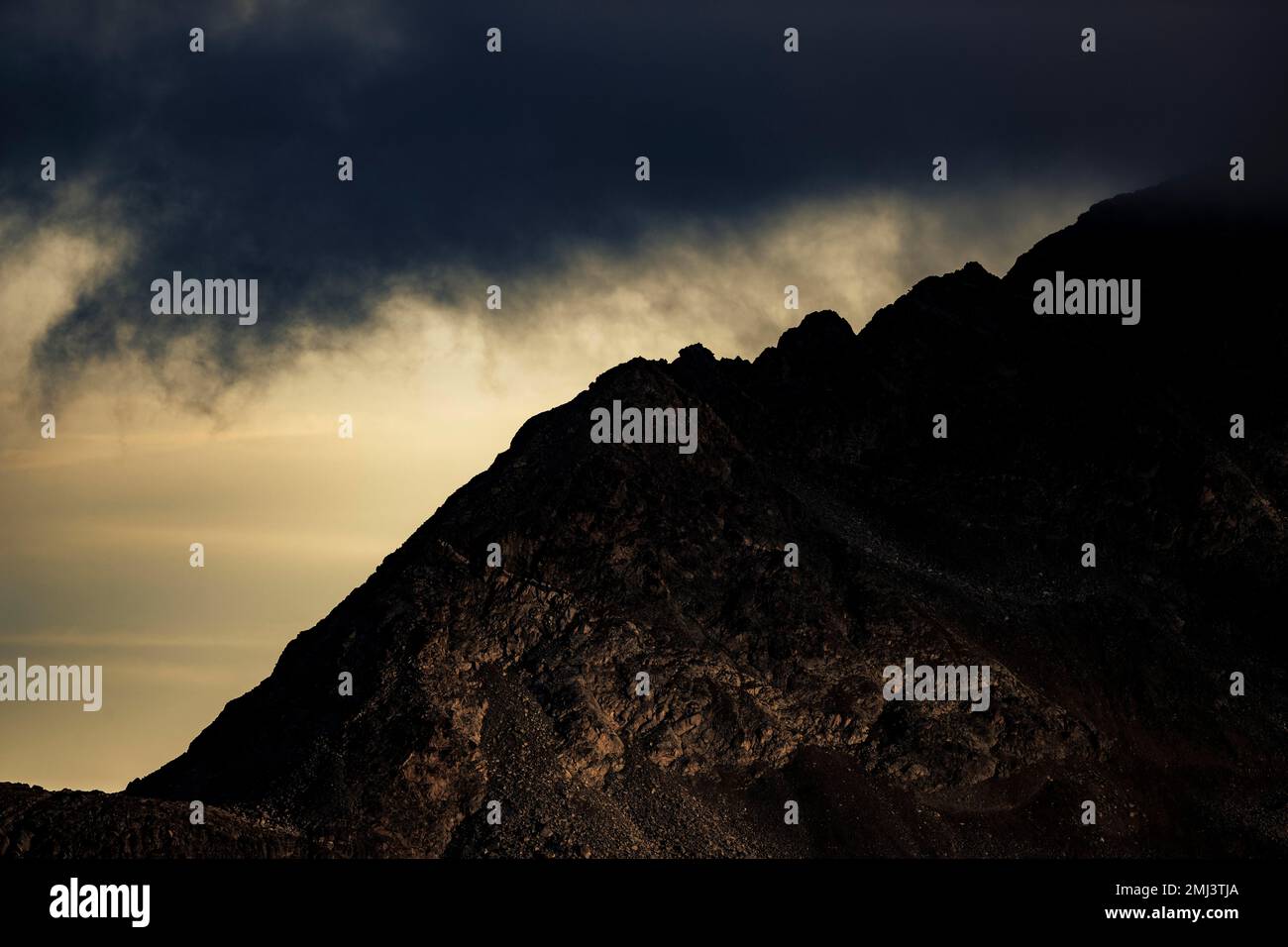 Dramatic clouds over Engadine mountains at blue hour, St Moritz, Engadine, Grisons, Switzerland Stock Photo