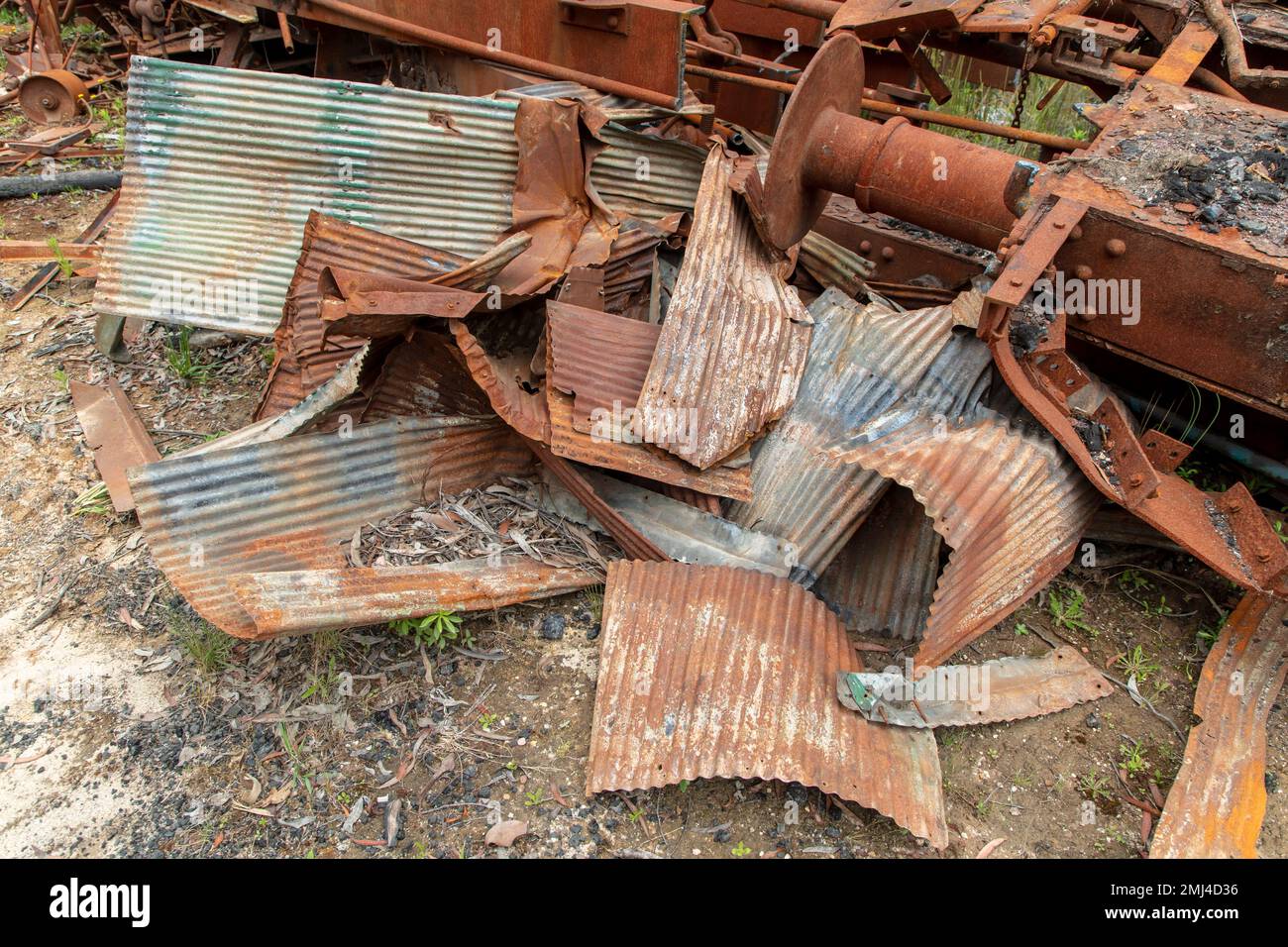 Photograph of old and rusty train carriage parts and metal that have been left dormant on the ground in a forest Stock Photo