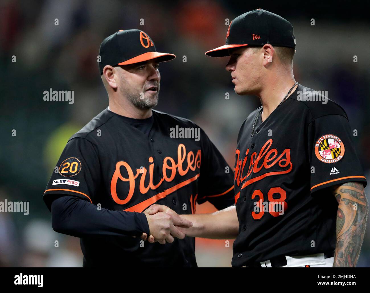 Baltimore Orioles manager Brandon Hyde, left, shakes hands with pitcher