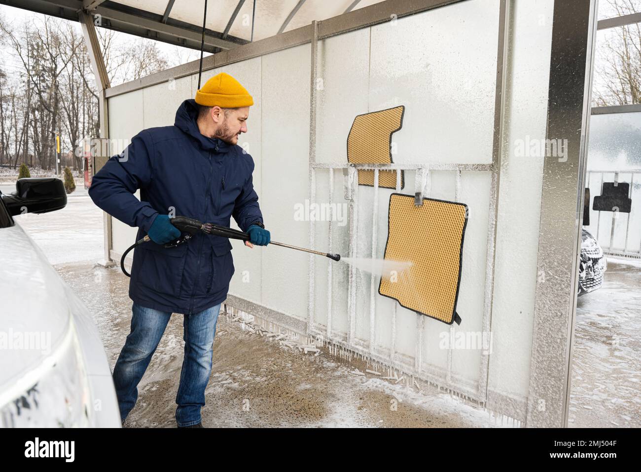 Man washing high pressure water car carpets at self service wash in cold weather Stock Photo Alamy