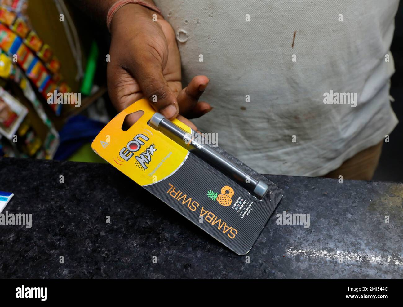 A roadside tobacco shop vendor displays an e cigarette in New Delhi, India,  Wednesday, Sept. 18, 2019. India's government on Wednesday decided to ban  e-cigarettes, expressing concern at the alarming rate at