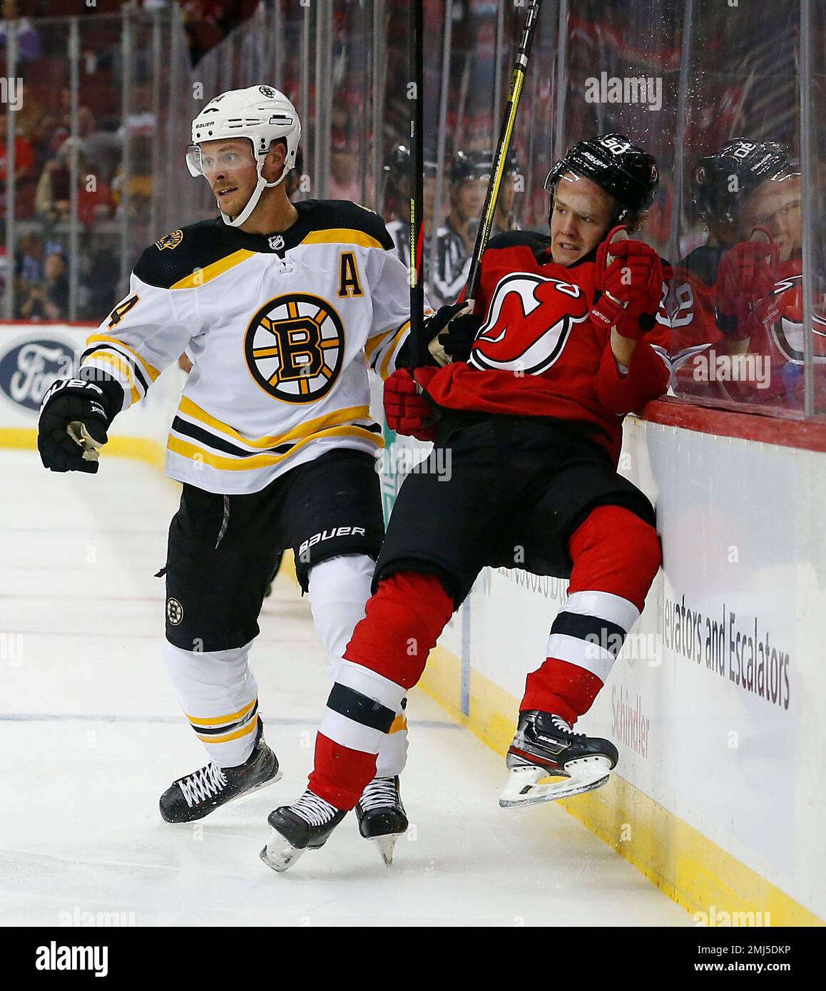 Boston Bruins right wing Chris Wagner (14) checks New Jersey Devils left  wing Taylor Hall (9) during the second period of a NHL pre-season hockey  game Monday, Sept.16, 2019, in Newark,N.J. (AP