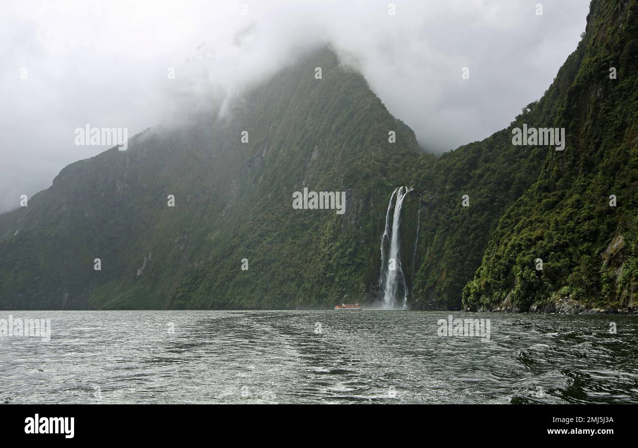 Ship and Stirling Falls - Fiordland NP, New Zealand Stock Photo