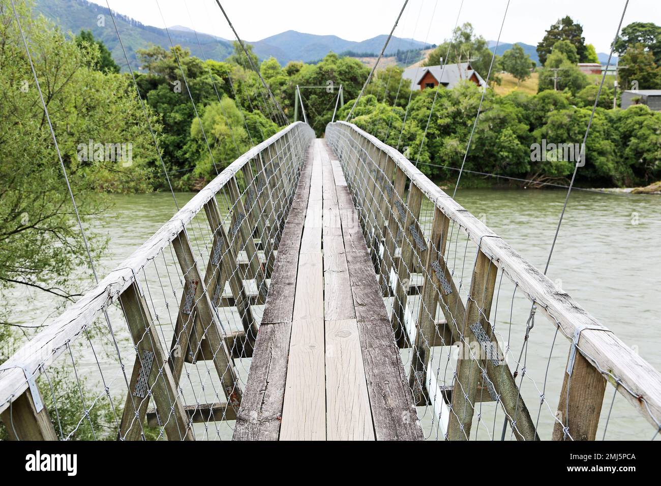 Walking on Pokororo swingbridge - New Zealand Stock Photo