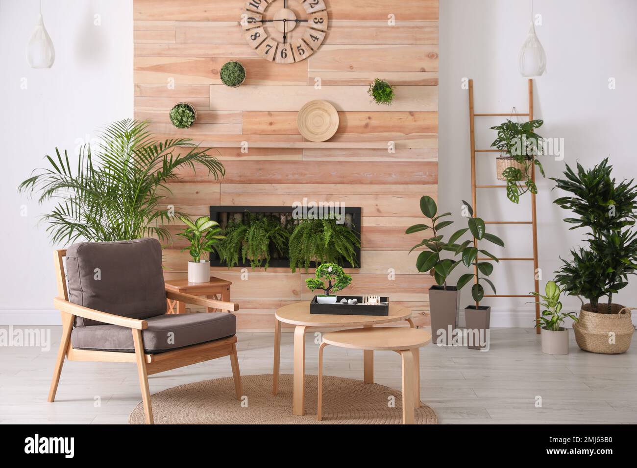 Stylish living room interior with armchair, green plants and miniature