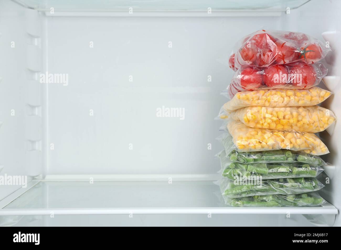Plastic bags with different frozen vegetables in refrigerator Stock Photo Alamy