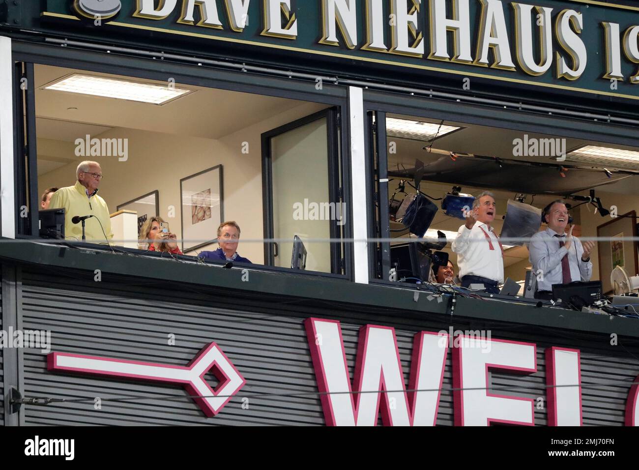 Cincinnati Reds radio announcer Marty Brennaman, left, stands in the booth as he is recognized by the Seattle Mariners during a baseball game Tuesday, Sept