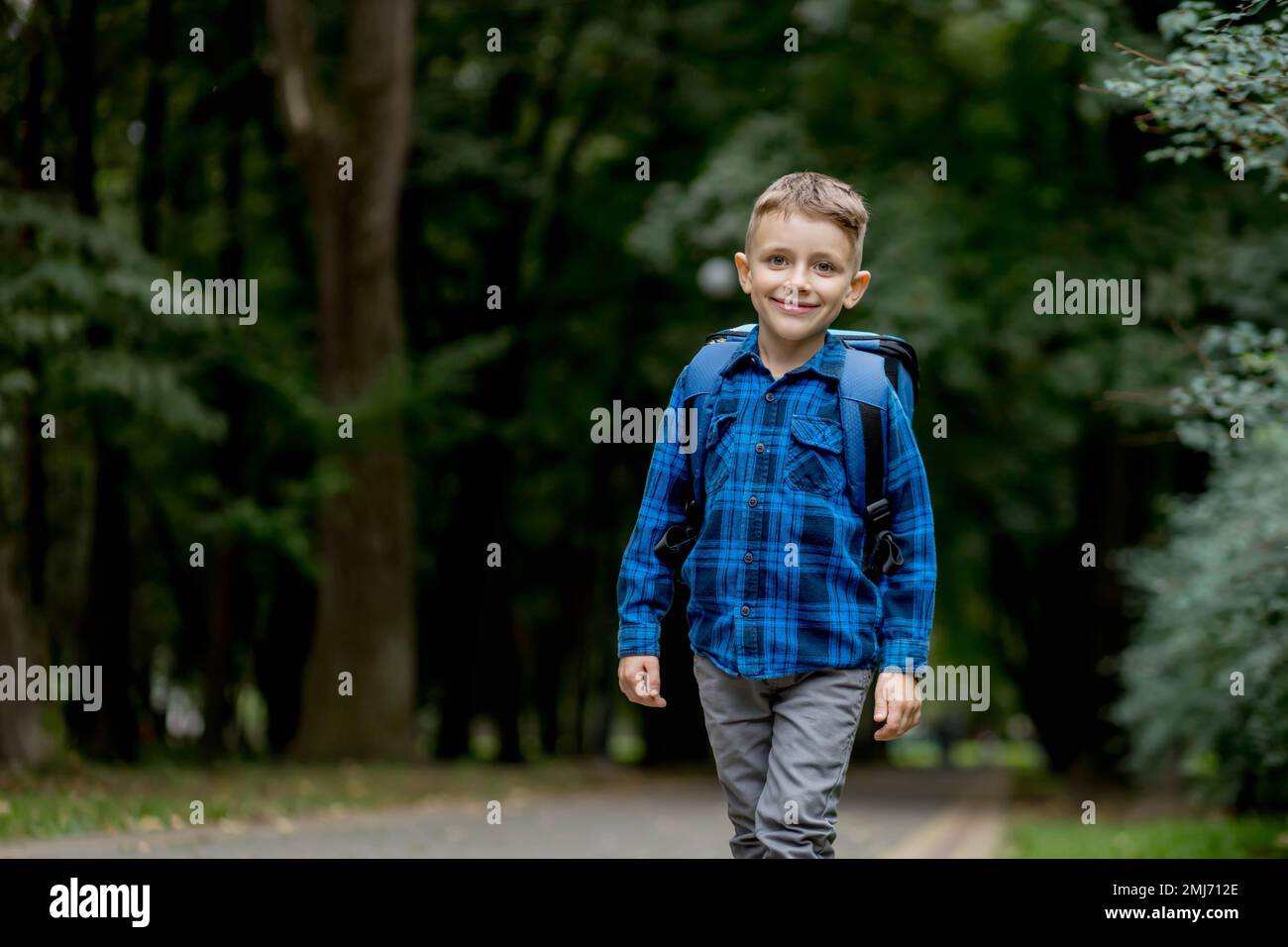 Portrait of a first grader with a backpack. The boy goes to school