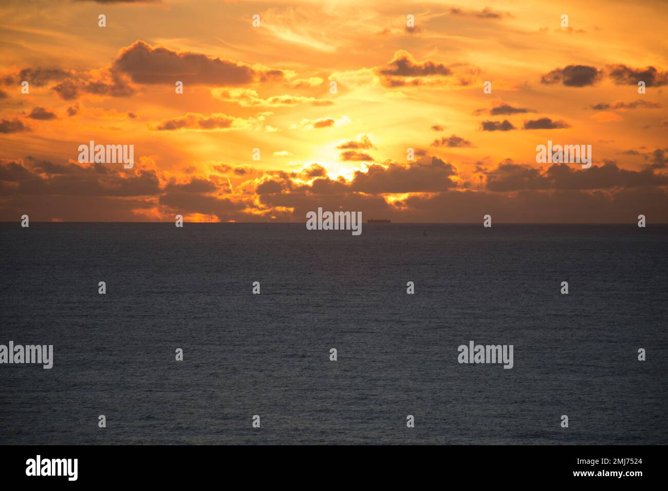 sunset at sea with ship, Atlantic Ocean, seen from Ribeira d'Ilhas, Ericeira - Portugal Stock Photo