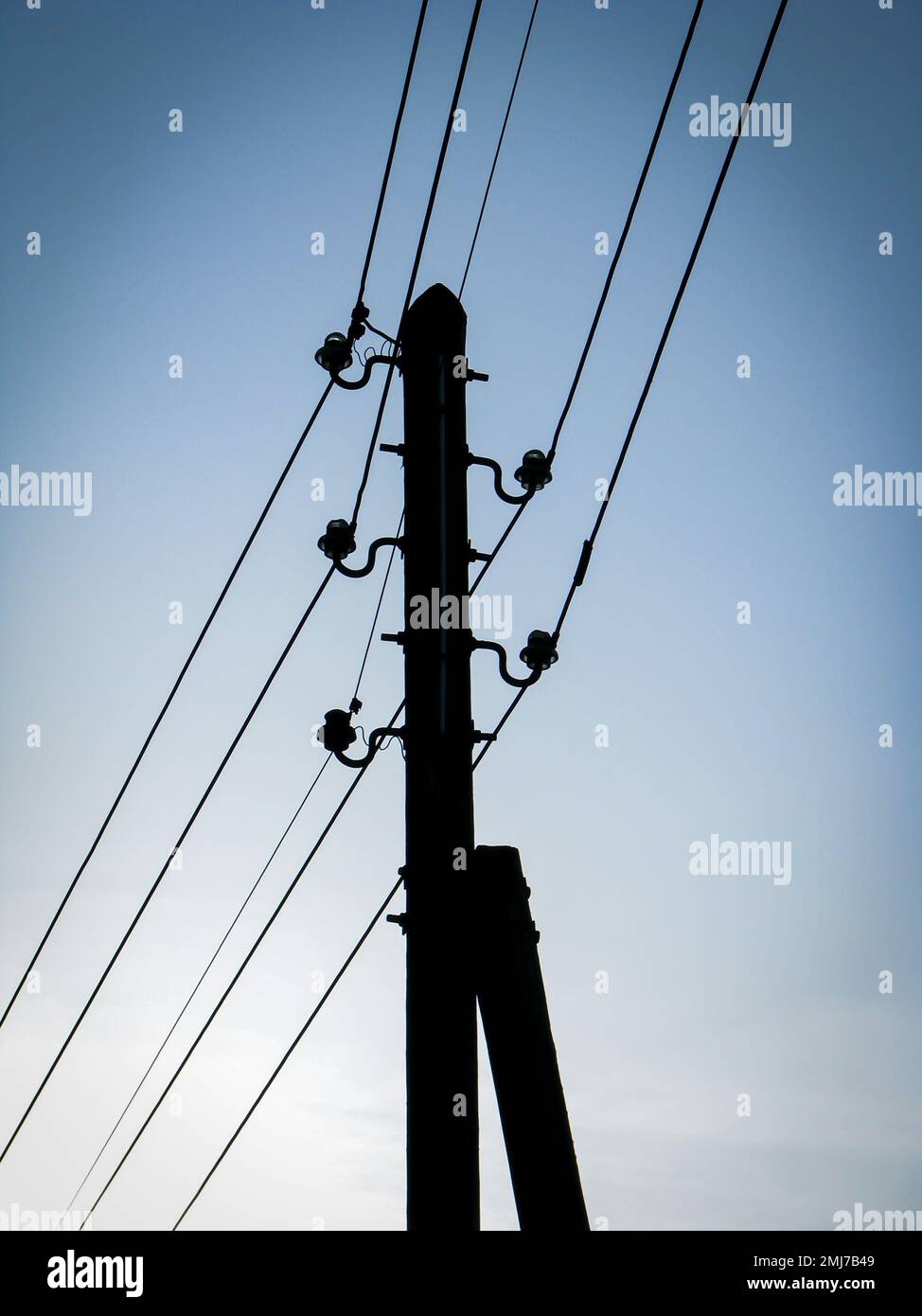 Silhoutte of an wooden old power pole. Overhead power lines can only be found in a few places in Germany. Stock Photo