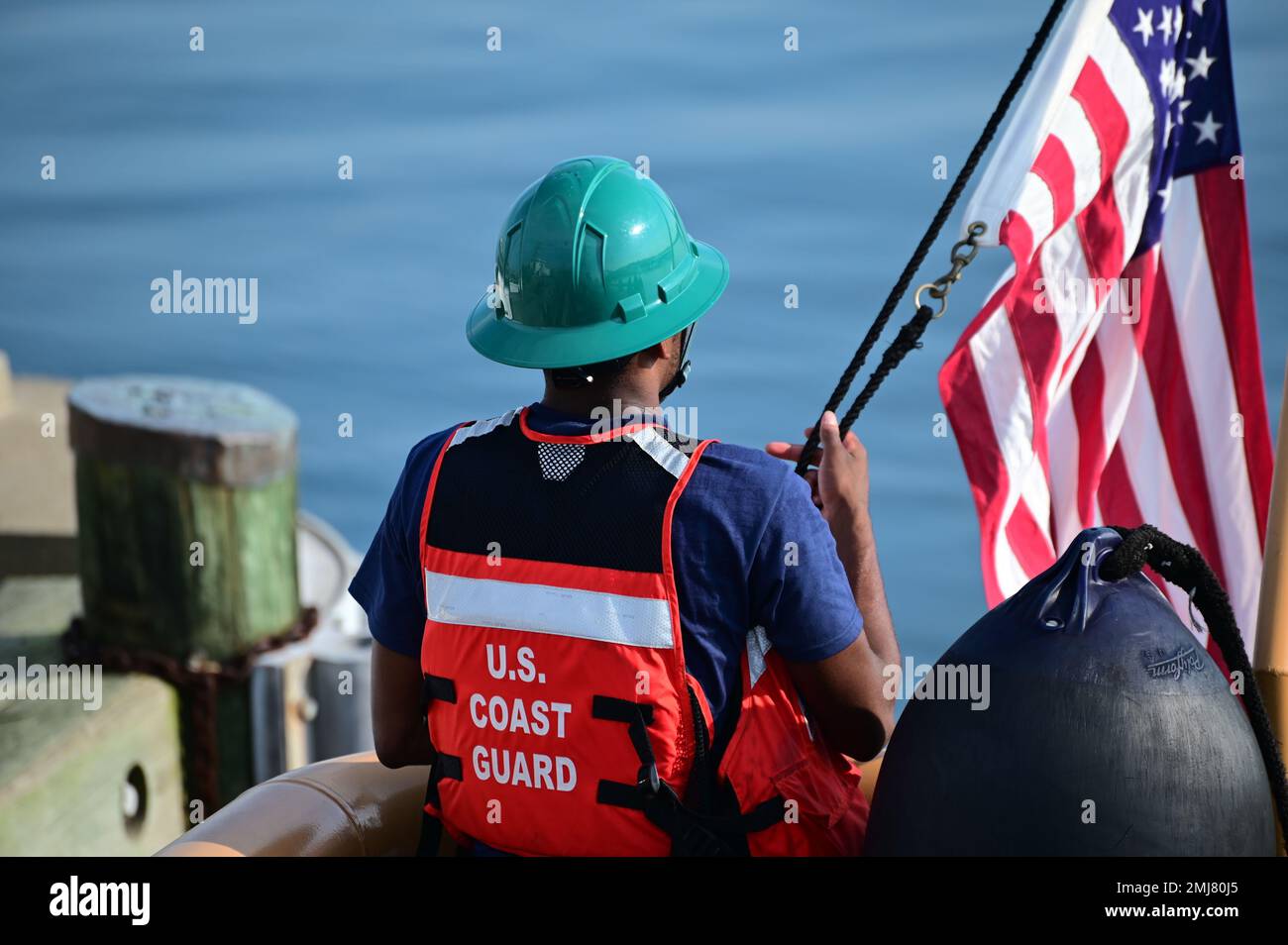A member aboard CGC Sailfish raises the American Flag during a mooring ...