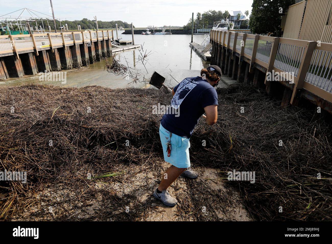 Walker Townsend clears marsh grass from the Isle of Palms marina boat  landing after Hurricane Dorian passed by the Isle of Palms, S.C., Friday,  September 6, 2019, in Charleston, S.C. (AP Photo/Mic