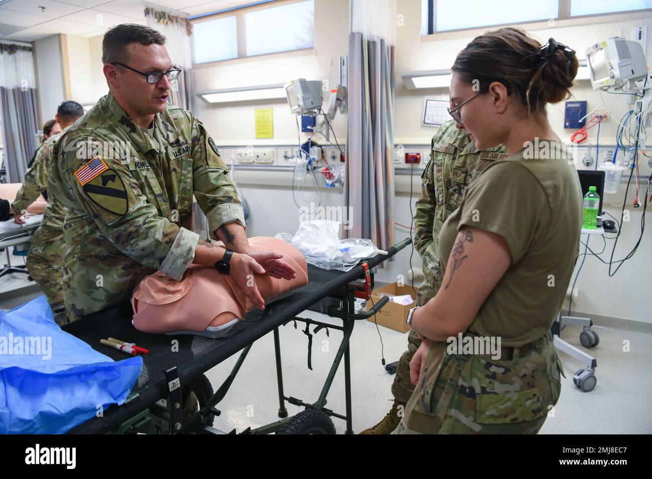 U.S. Army Sgt. 1st Class Bryan Rowland, U.S. Army Medical Department Activity Bavaria NCOIC of education and training, left, teaches A1C Justice Nerad, 31st Health Care Operations Squadron aerospace medical technician, right, how to treat a collapsed lung using a training mannequin at Aviano Air Base, Italy, Aug. 25, 2022. Two scenarios simulated during the joint training were a pneumothorax and hemothorax, which is the name of the condition when trapped air or trapped blood respectively leaks out of the lung into the chest cavity. Stock Photo
