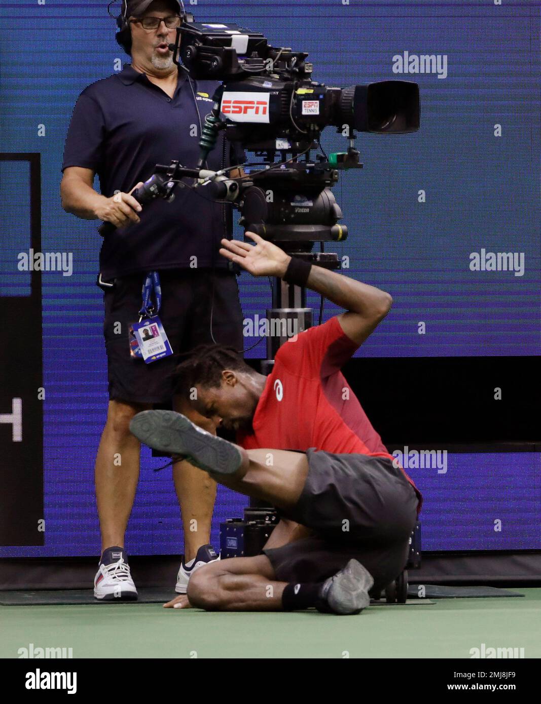 Gael Monfils, of France, nearly runs into a television cameraman while returning a shot from Matteo Berrettini, of Italy, during the quarterfinals of the U.S