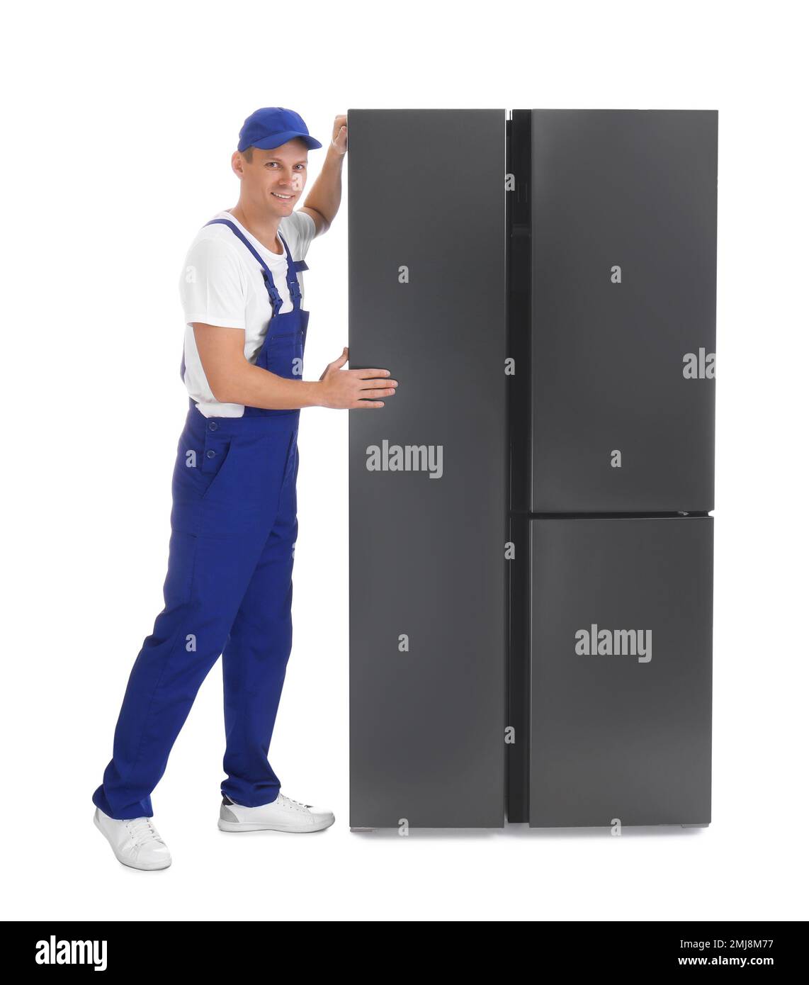 Professional worker carrying refrigerator on white background Stock