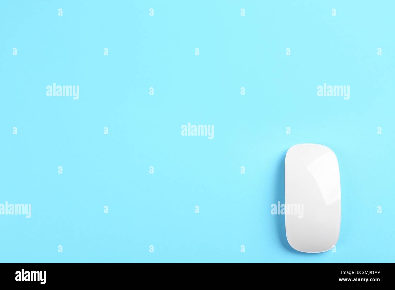 Modern wireless optical mouse on light blue background, top view. Space for text Stock Photo