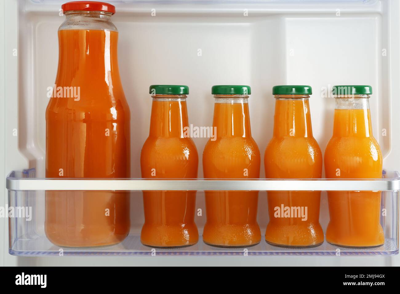Bottles of juice on shelf in refrigerator Stock Photo Alamy