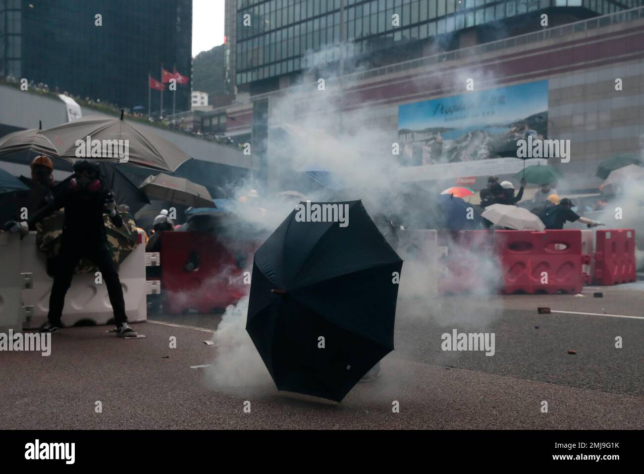A protestor bends to pick up an exploded tear gas shell in central Hong ...