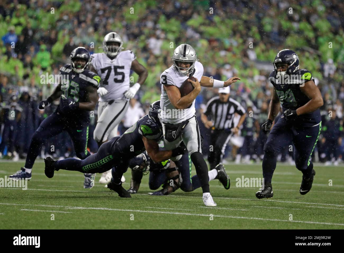 Oakland Raiders quarterback Nathan Peterman (3) scrambles, but Seattle  Seahawks linebacker Cody Barton (57) makes the tackle during the first half  of an NFL football preseason game Thursday, Aug. 29, 2019, in