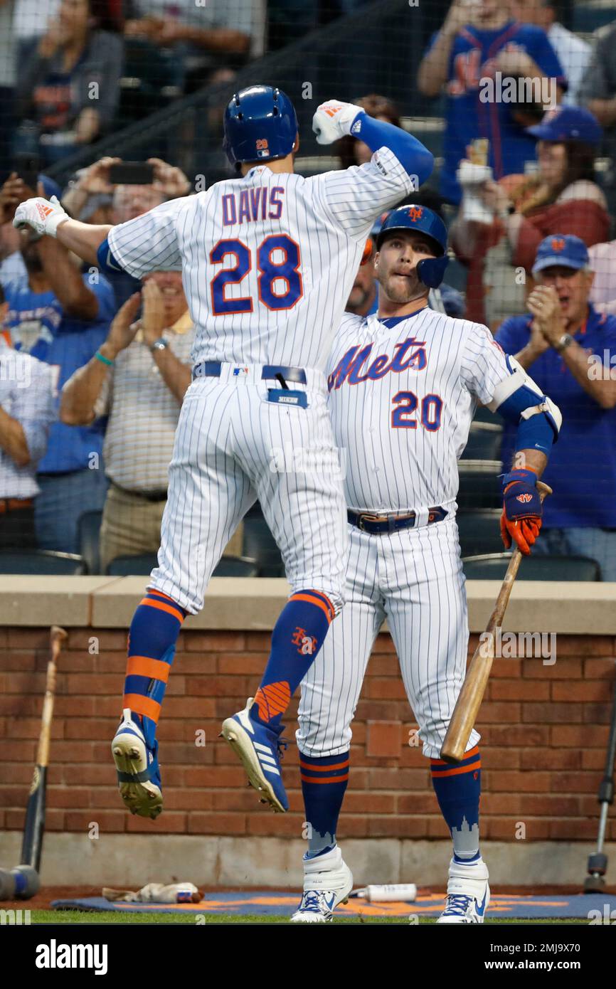 New York Mets on-deck batter Pete Alonso (20) celebrates with teammate J.D.  Davis (28) after Davis hit a solo home run off Chicago Cubs starting  pitcher Jon Lester during the first inning